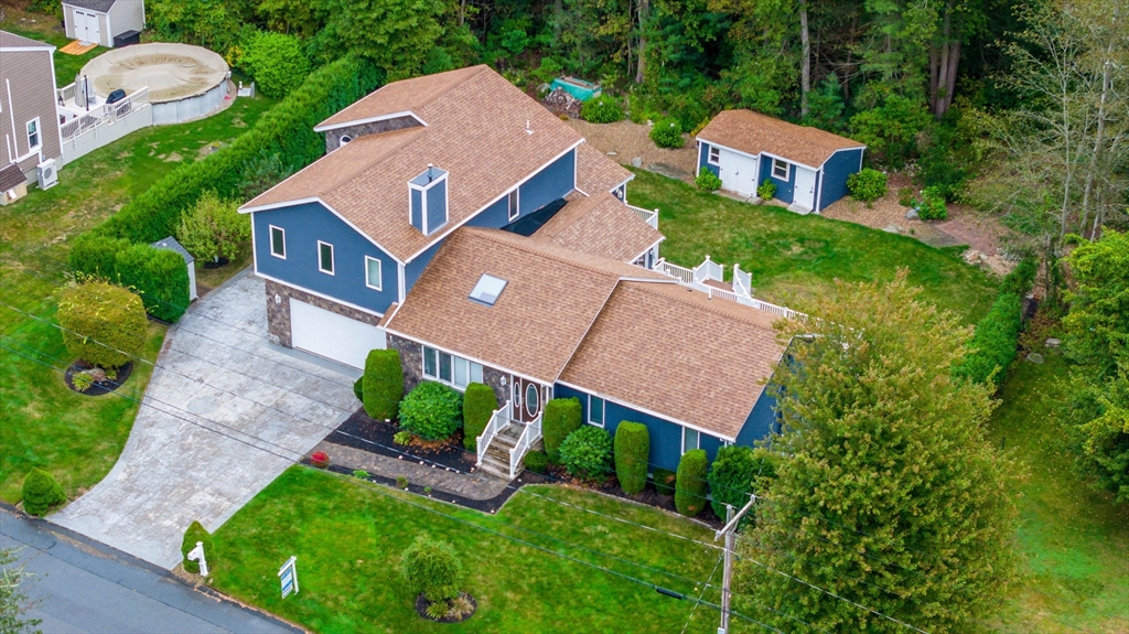 a aerial view of a house with a yard and tree s