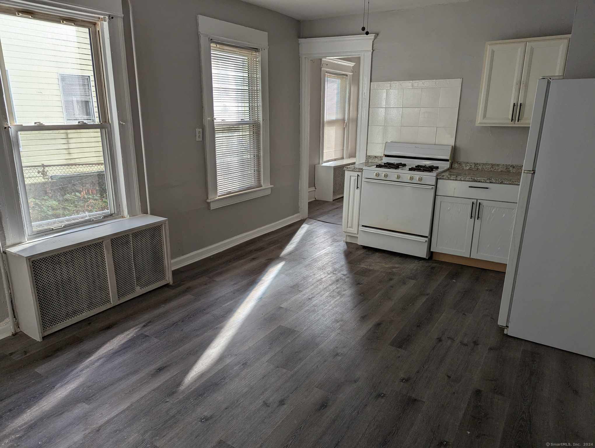 a kitchen with cabinets wooden floor and stainless steel appliances