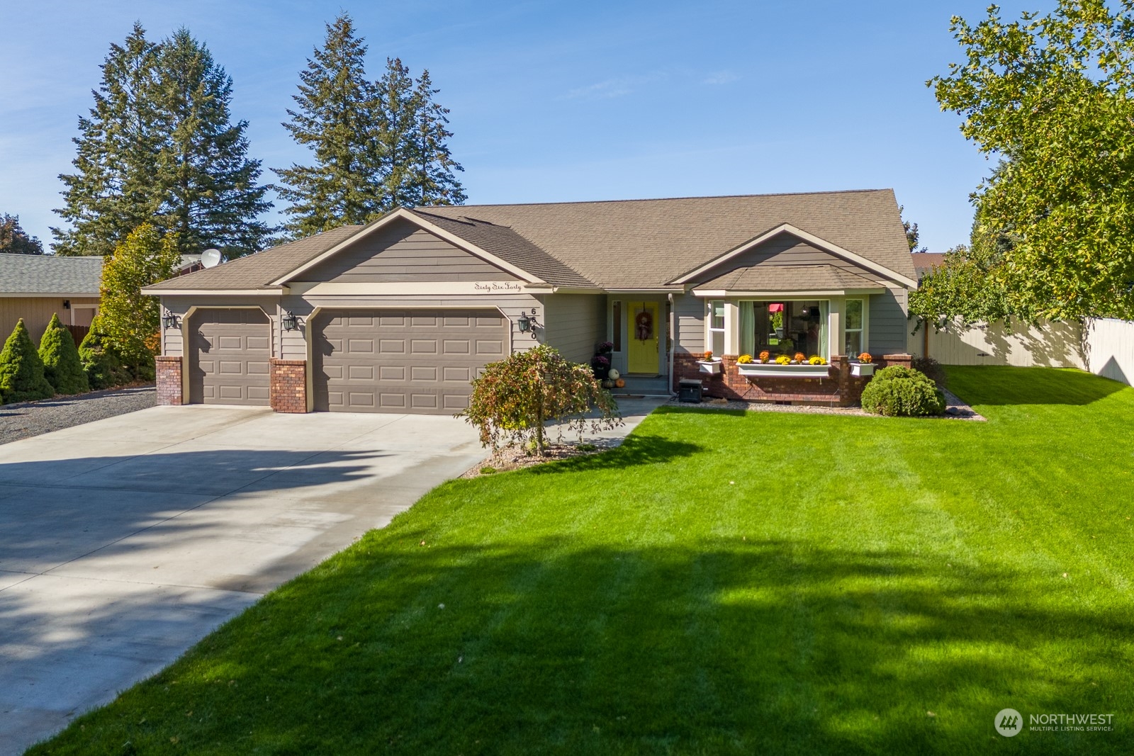 a front view of a house with a garden and trees