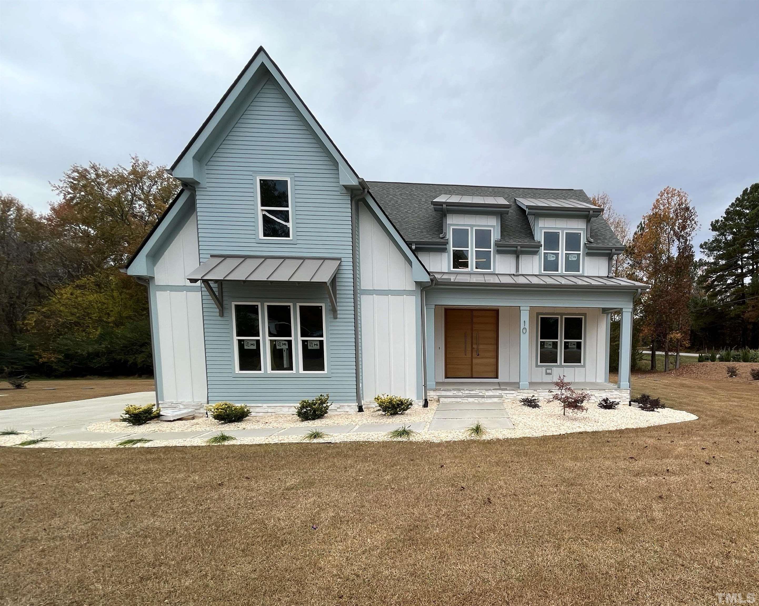 a front view of house with yard outdoor space and porch