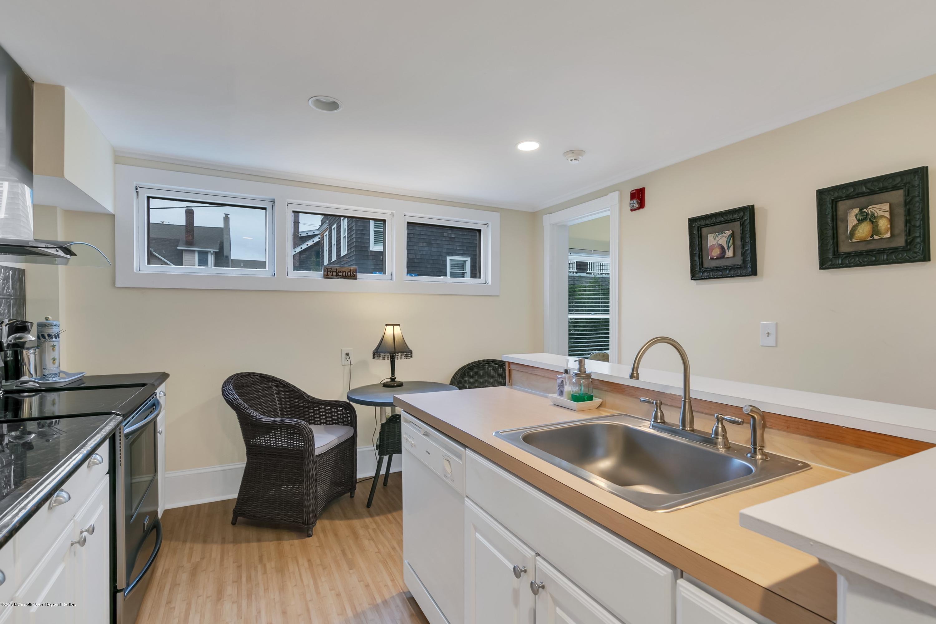 a kitchen with a sink cabinets and wooden floor