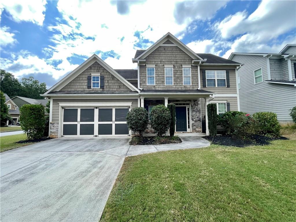 a front view of a house with yard and green space