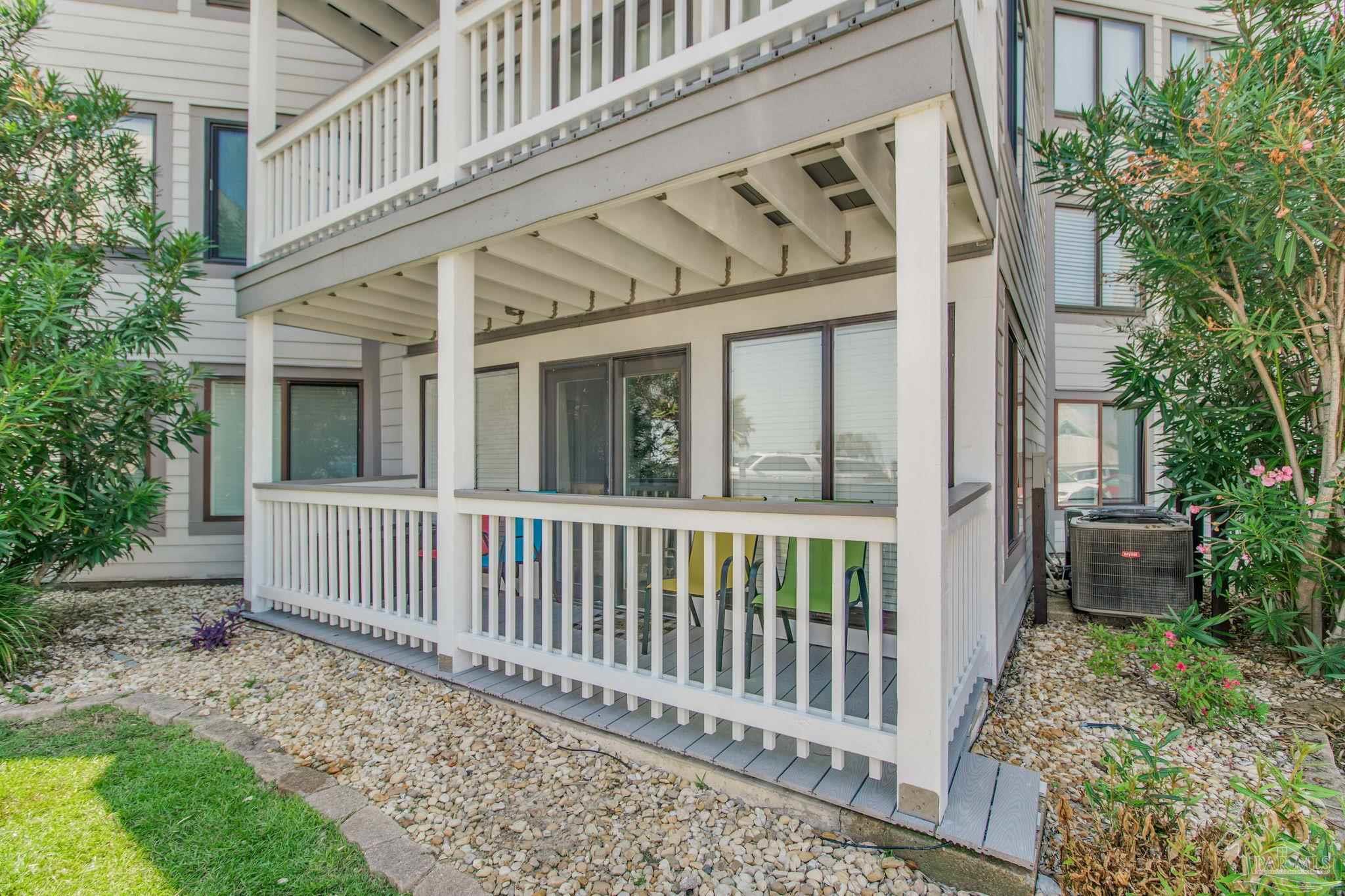 a porch with a bench next to a yard