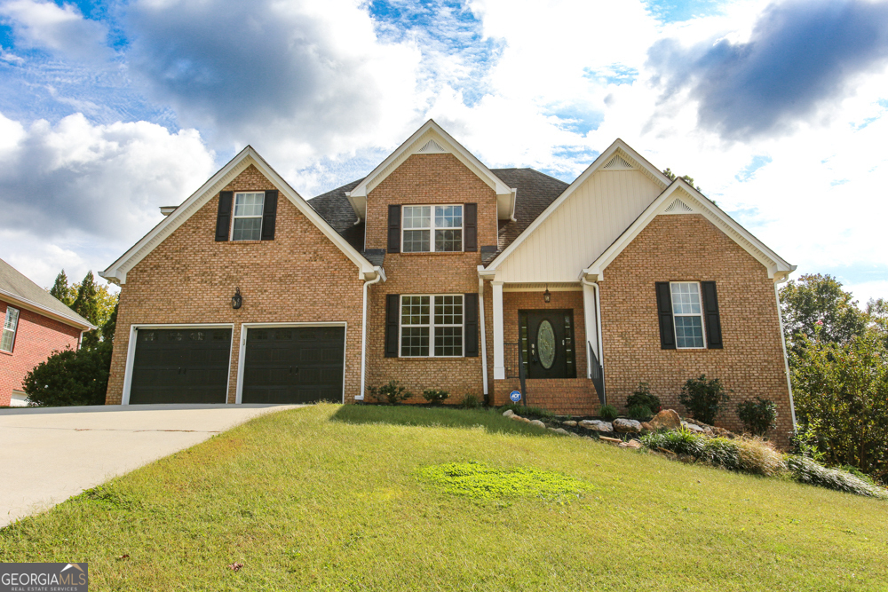 a front view of a house with a yard and garage