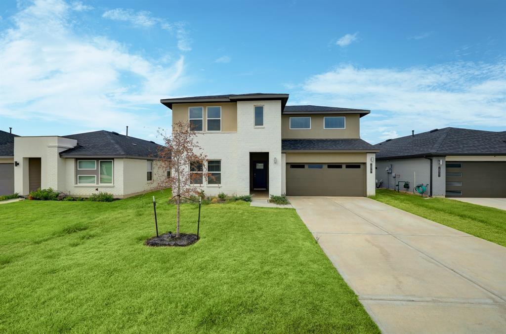 a front view of a house with a garden and yard