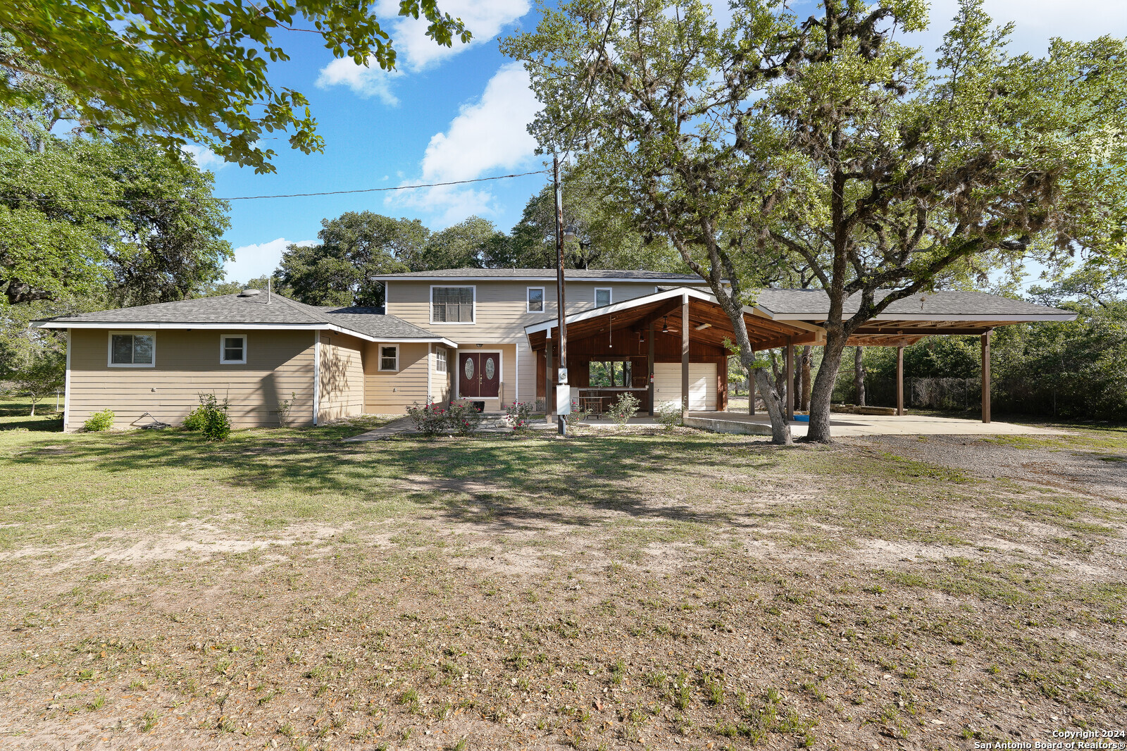 a view of a house with backyard and trees