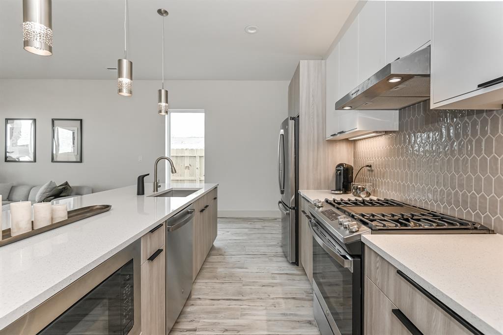 a kitchen with stainless steel appliances a sink stove and cabinets