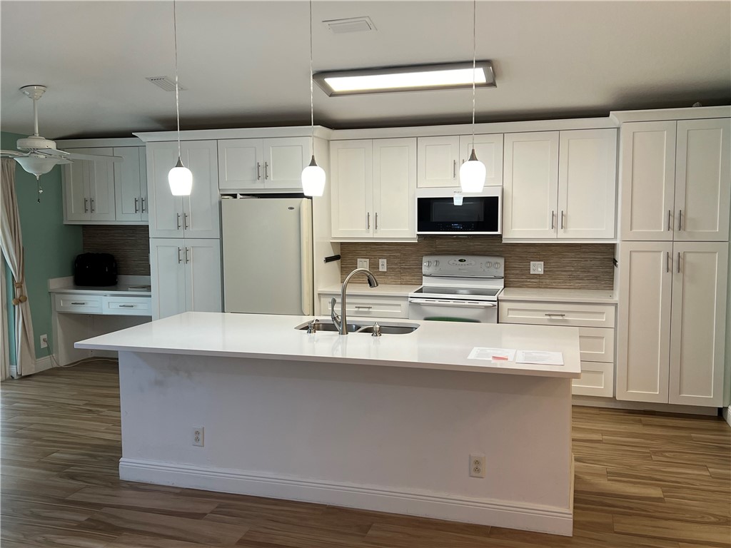 a kitchen with kitchen island white cabinets and stainless steel appliances