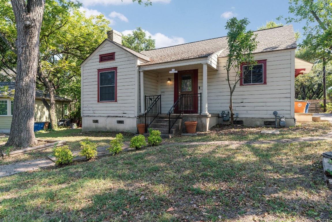 a view of a house with backyard and a tree