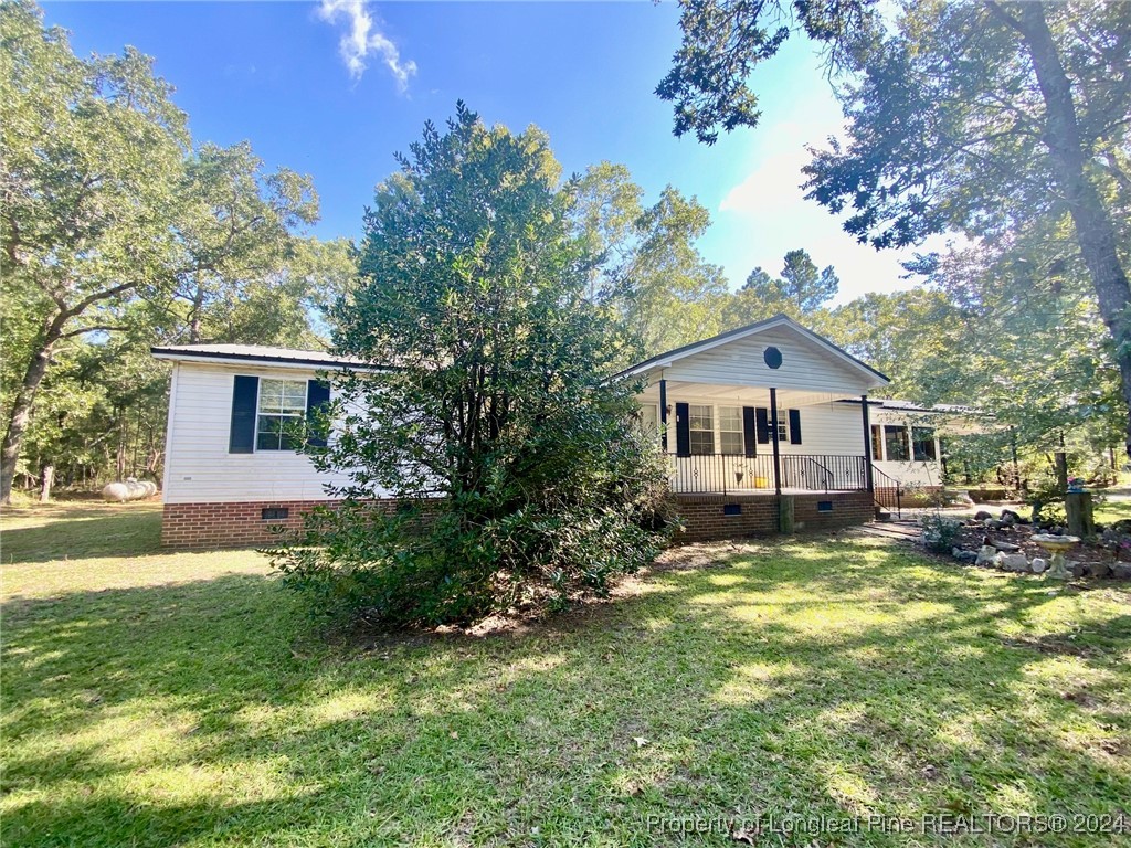 a front view of a house with a yard and trees