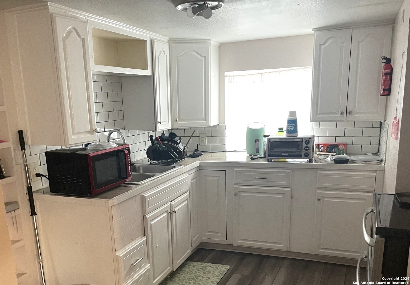 a kitchen with white cabinets and white appliances