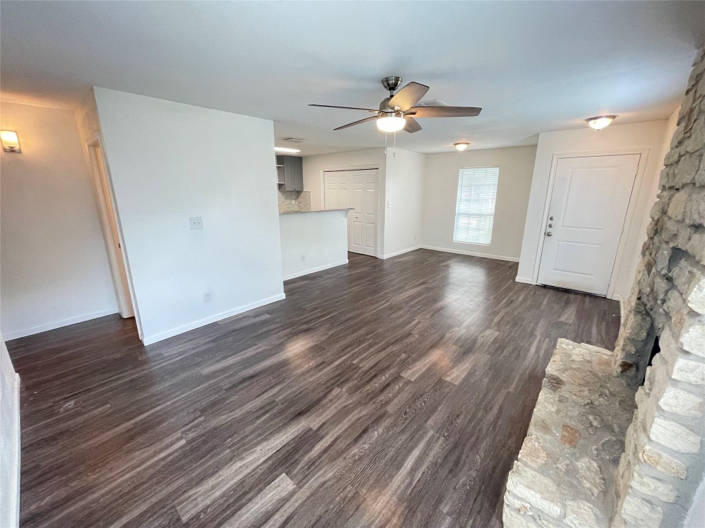 a view of empty room with wooden floor and ceiling fan