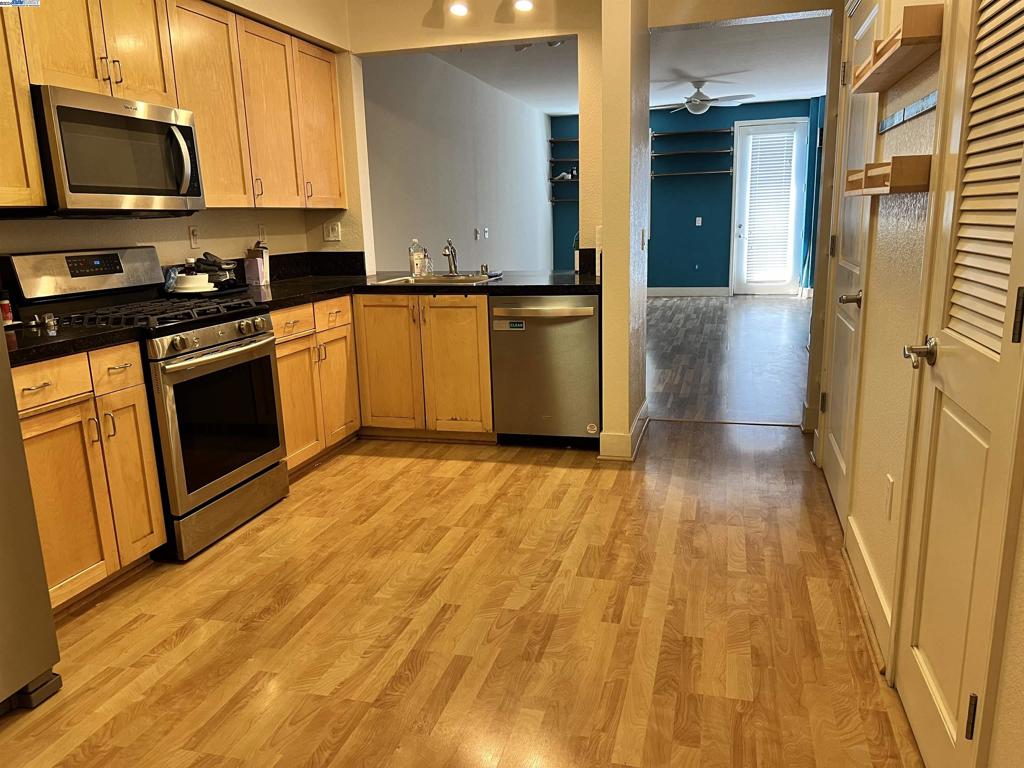 a kitchen with wooden floors and stainless steel appliances