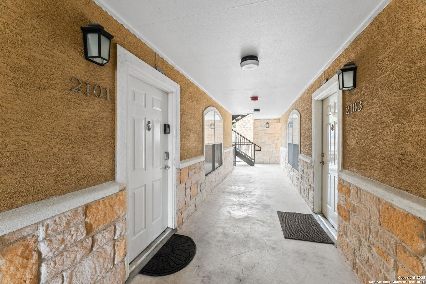 a view of a hallway to a livingroom with furniture