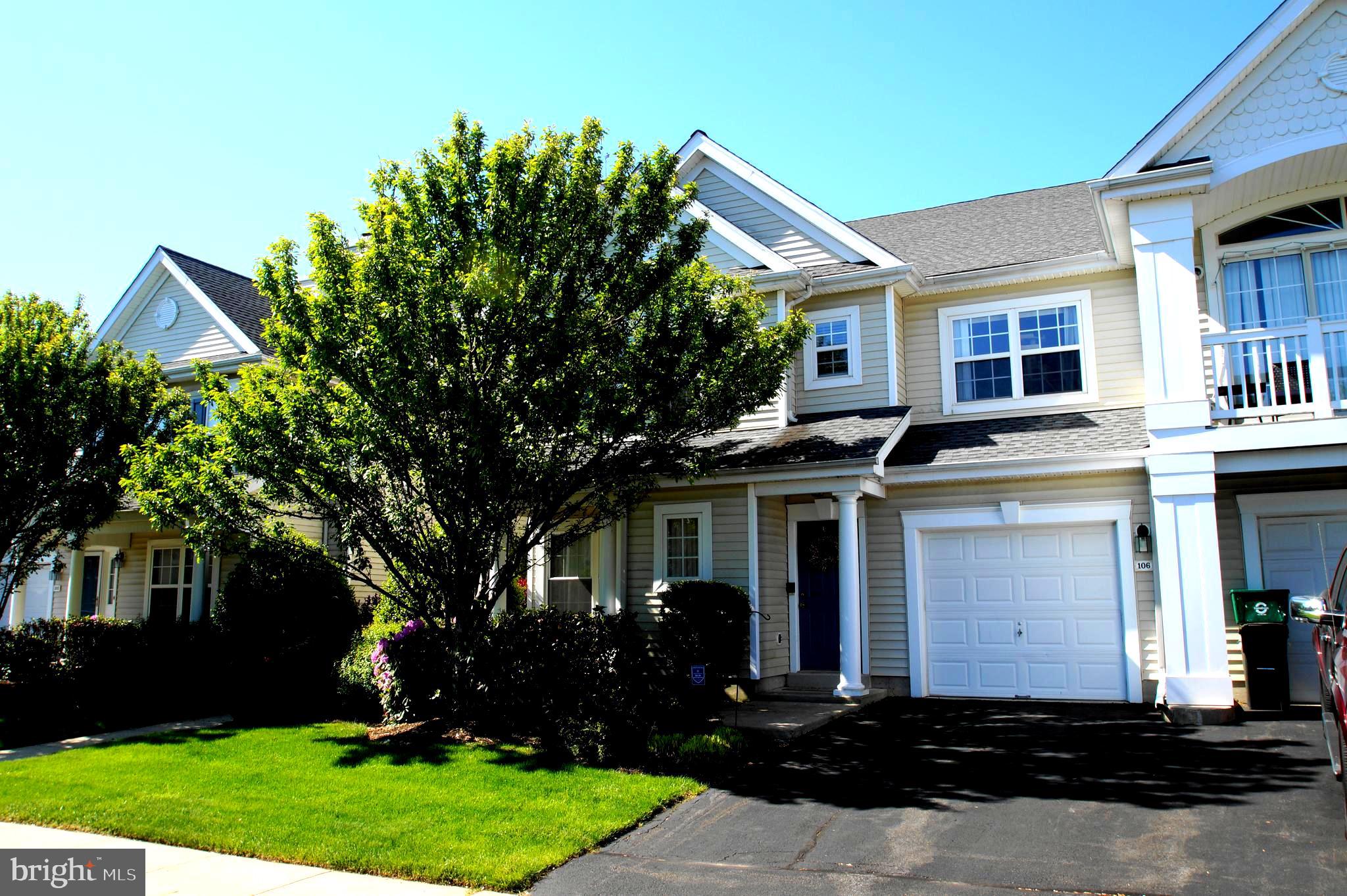 a front view of a house with a yard and trees