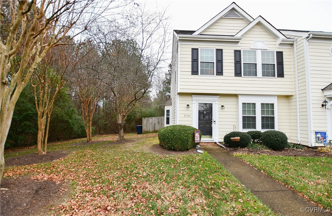 a view of a house with a backyard and a tree