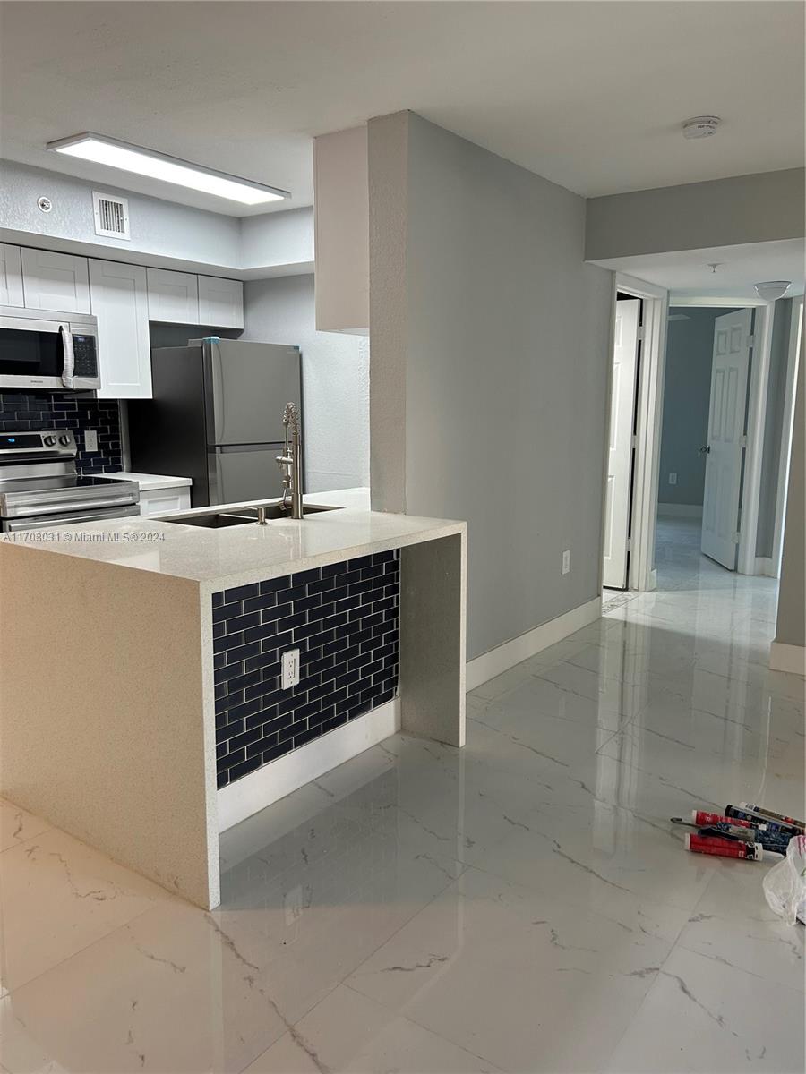 a kitchen with stainless steel appliances granite countertop a sink and a stove