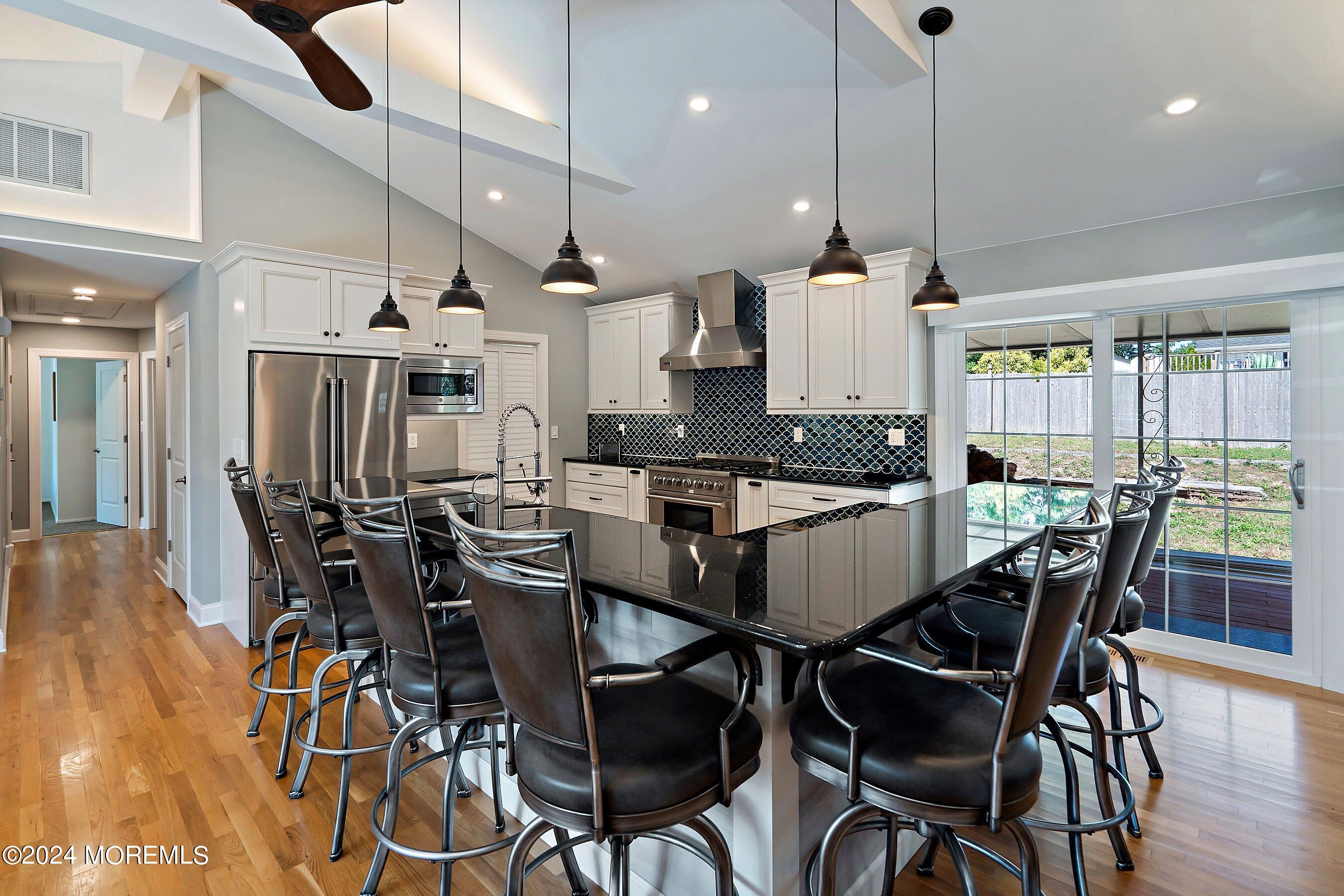 a kitchen with stainless steel appliances kitchen island a large island a stove a table and chairs