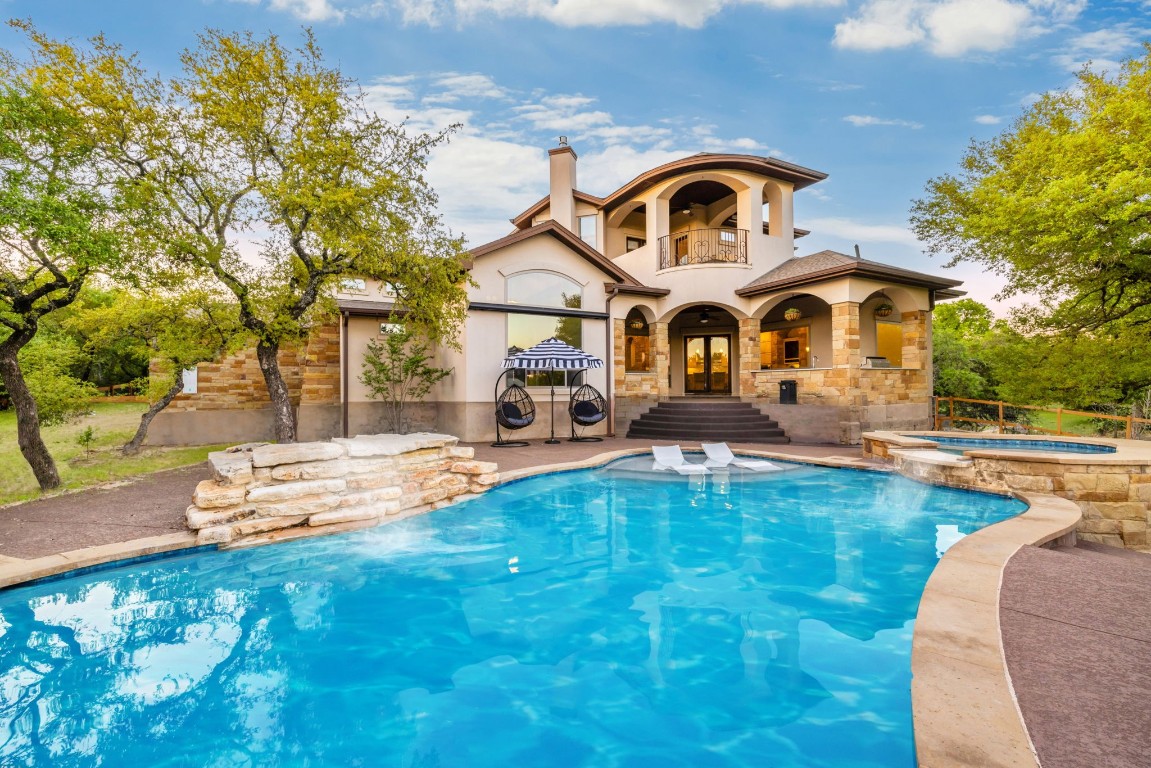 a front view of a house with swimming pool and porch