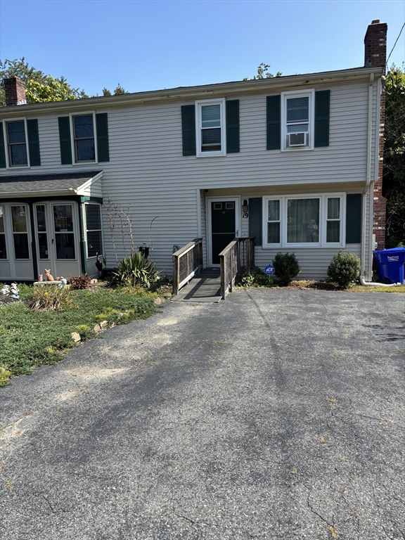 a view of a house with a yard and sitting area