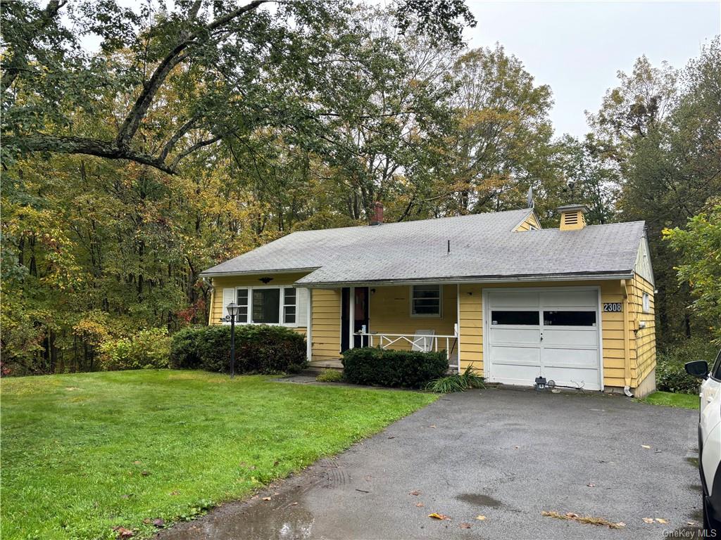 Front of home with 1 car garage and parking for 4 cars.