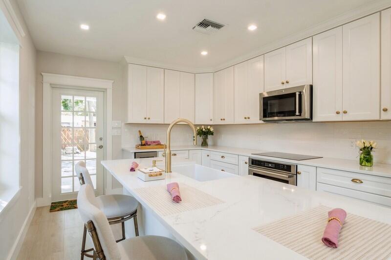 a kitchen with kitchen island white cabinets and white appliances