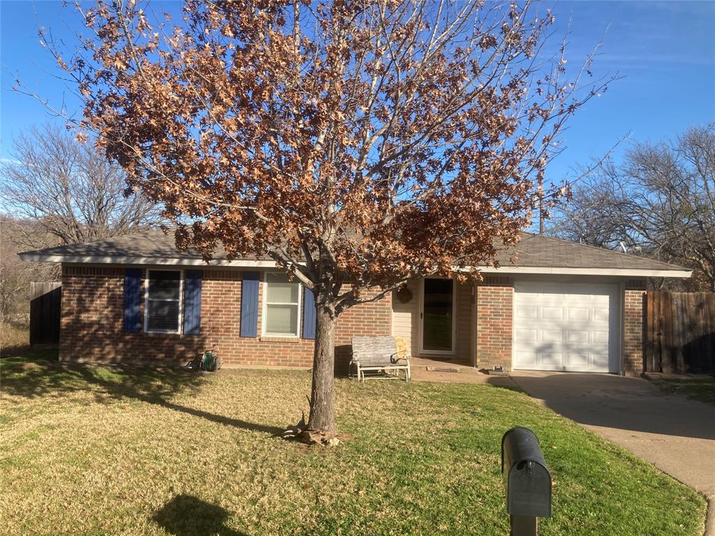 front view of a house with a large tree