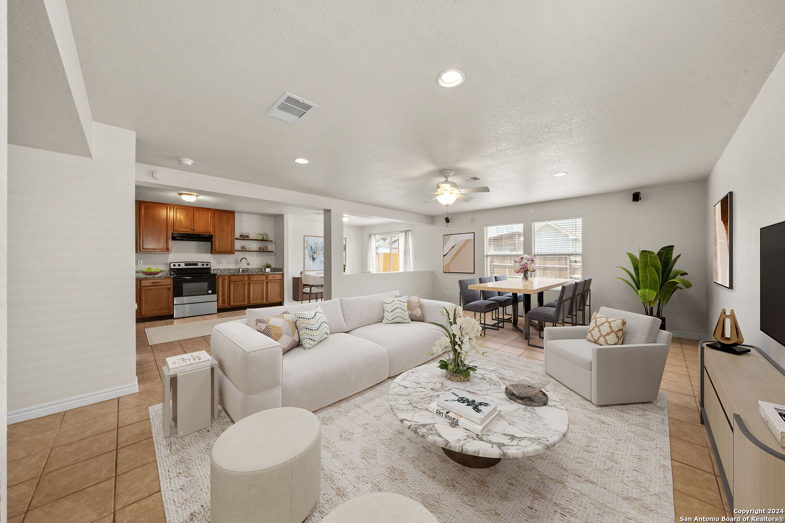 a living room with furniture kitchen view and a potted plant