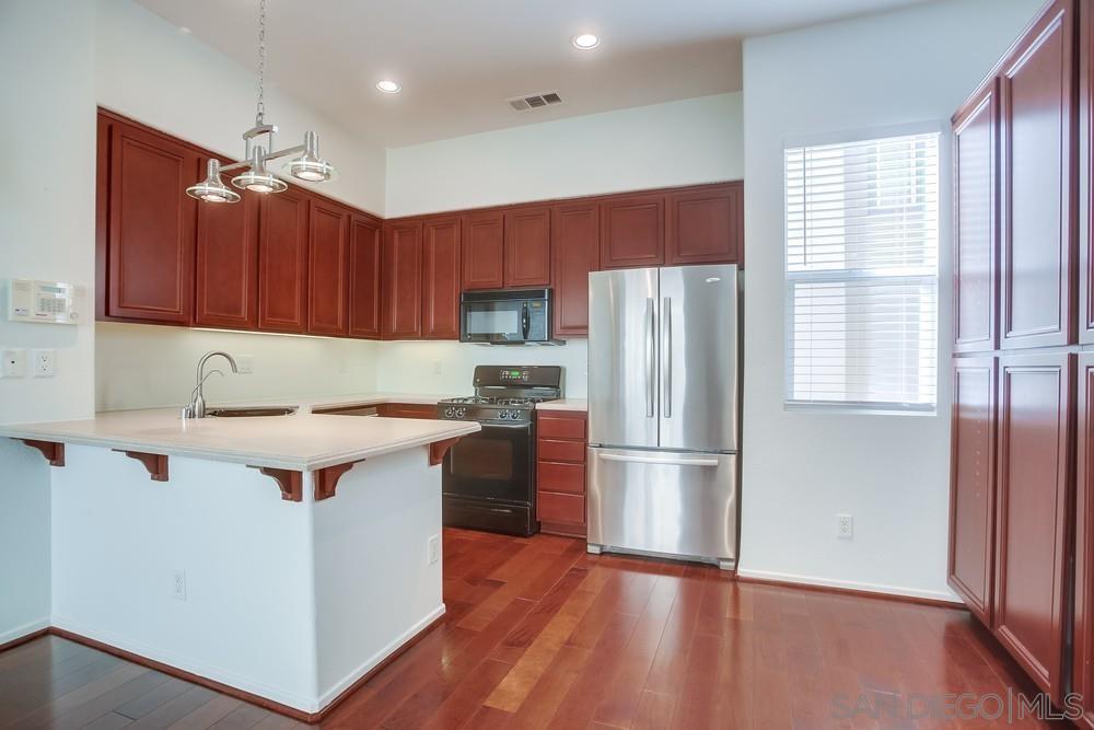 a kitchen with a refrigerator sink and cabinets