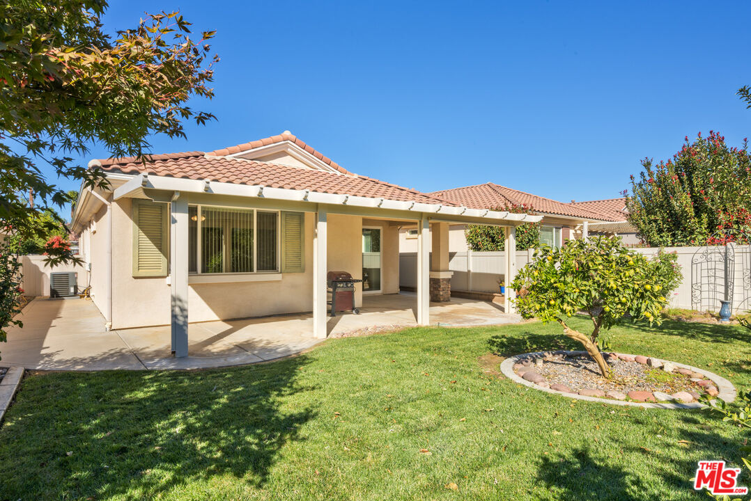 a view of a house with a yard and sitting area