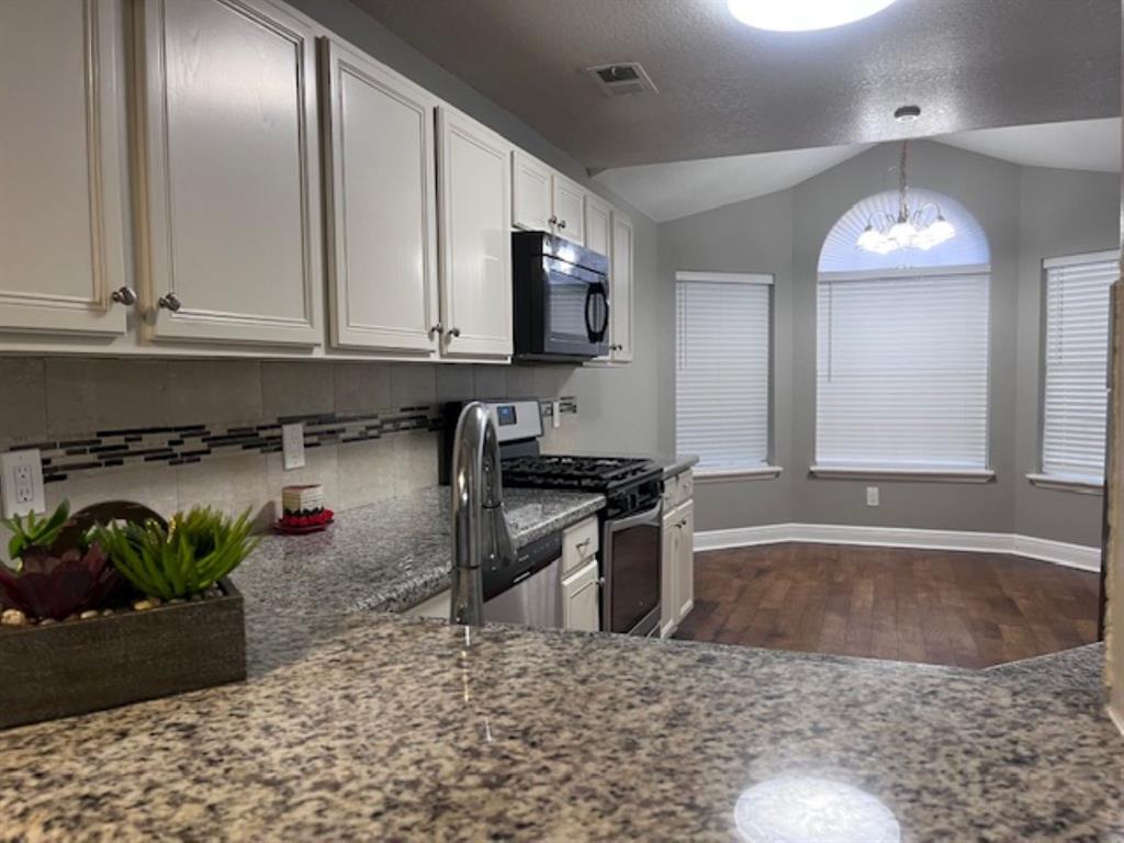 a kitchen with granite countertop a stove a sink and a granite counter tops