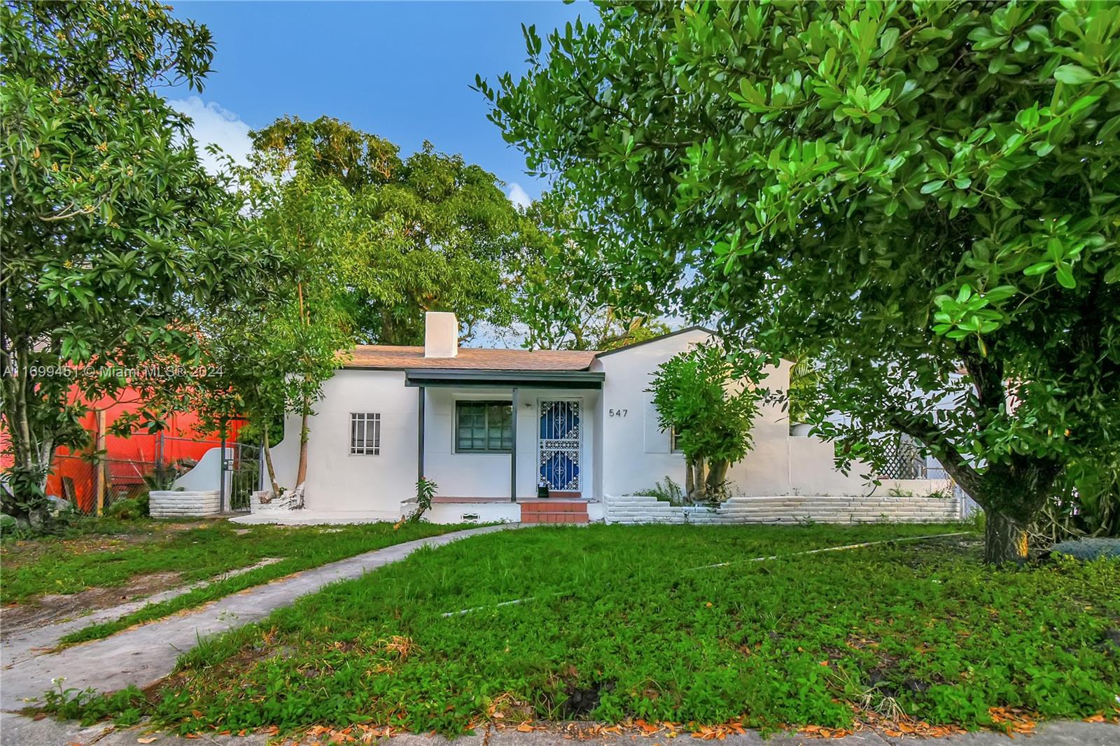 a view of a house with backyard and a tree