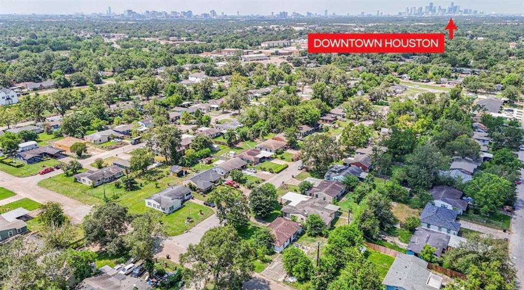 an aerial view of residential houses with outdoor space and trees