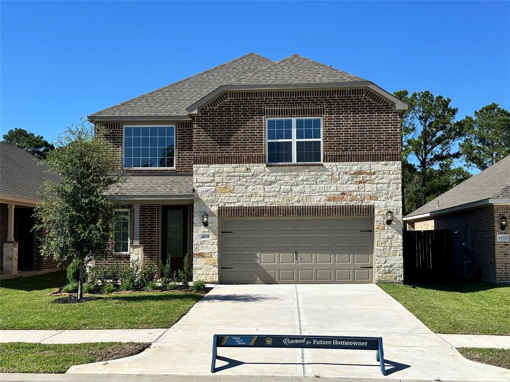 The Sequoia is a beautiful two-story home with a unique two-tone brick and stone design. The home has front yard landscaping and upgraded light fixtures on either side of the garage, with large windows for added curb appeal.