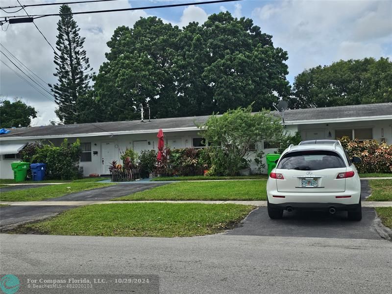 a view of a car parked in front of a house and cars parked