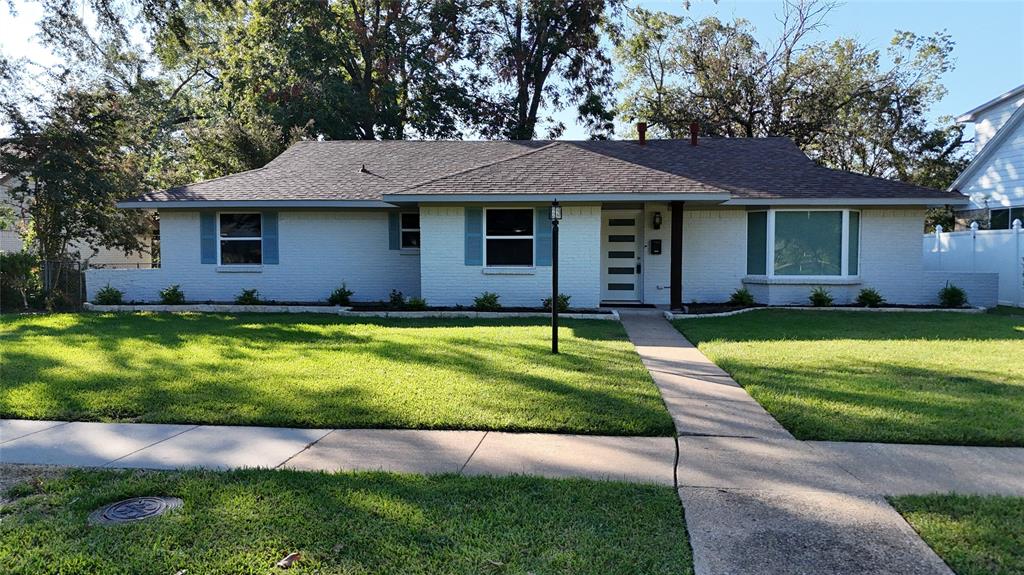 a front view of a house with a yard and trees