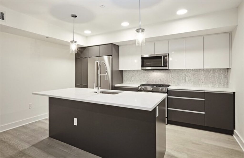 a kitchen with kitchen island a sink stainless steel appliances and cabinets