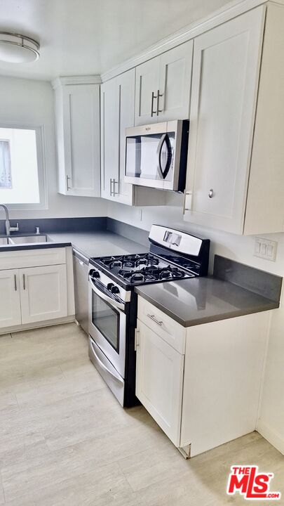 a kitchen with stainless steel appliances granite countertop a sink and cabinets