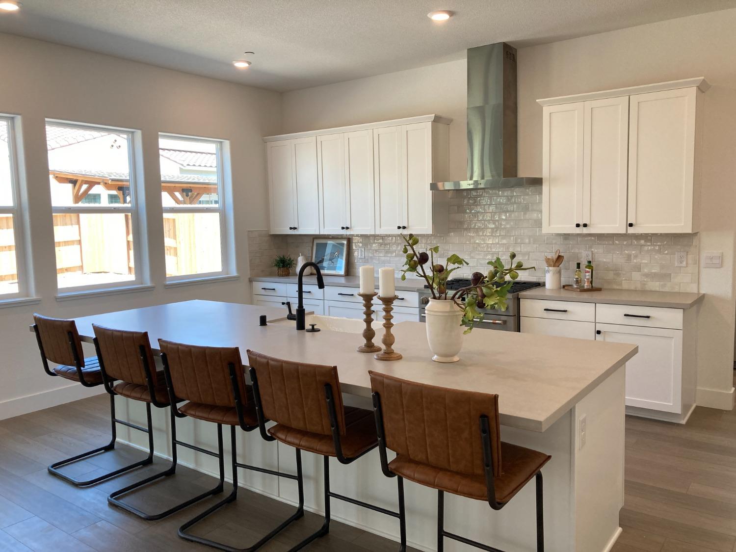 a kitchen with a dining table chairs and white appliances