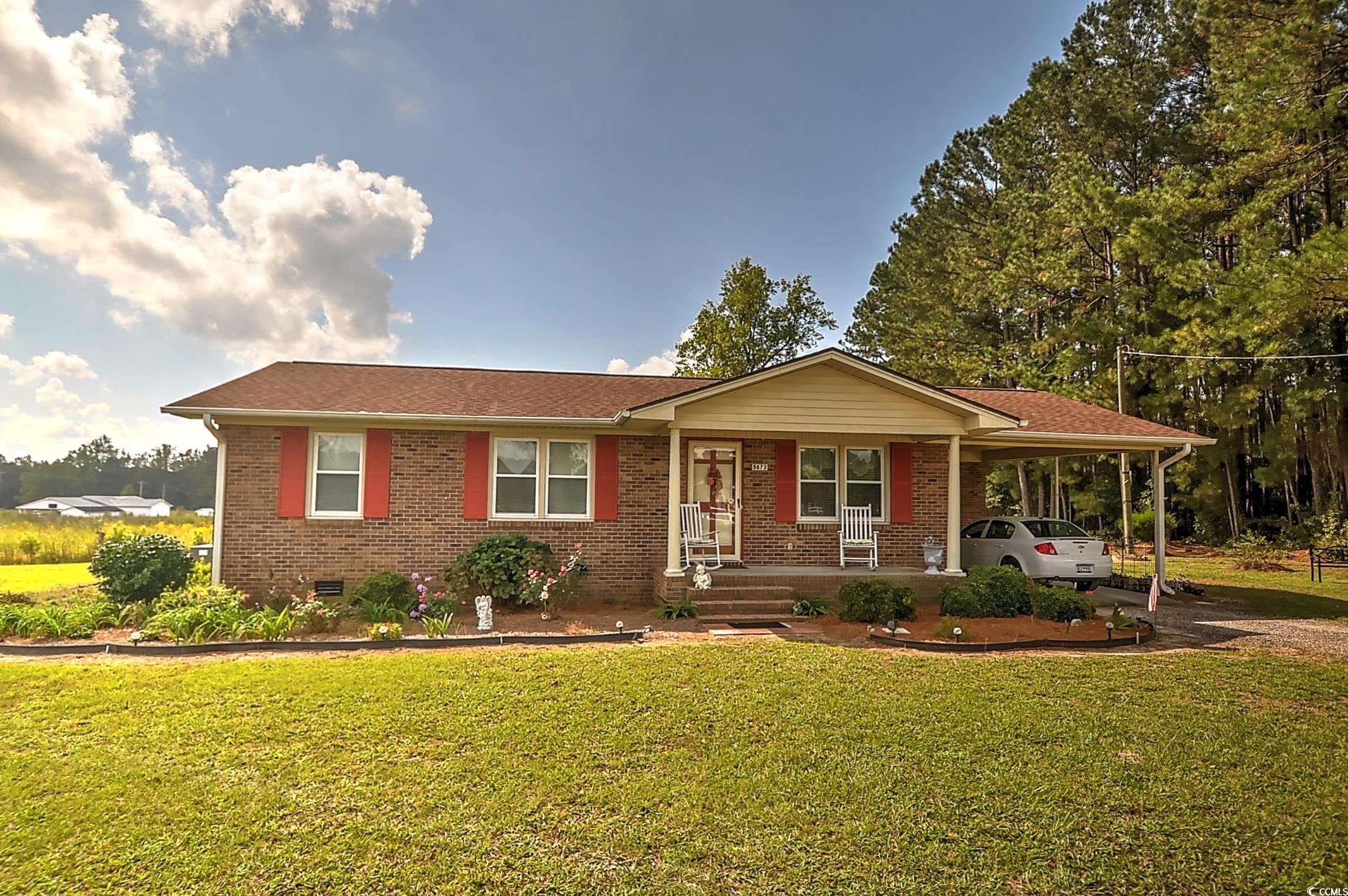 View of front of property featuring a carport, a p