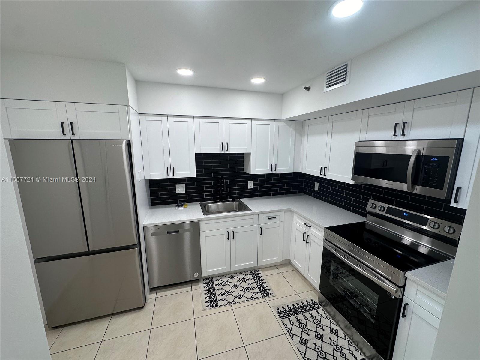 a kitchen with a refrigerator and a stove top oven