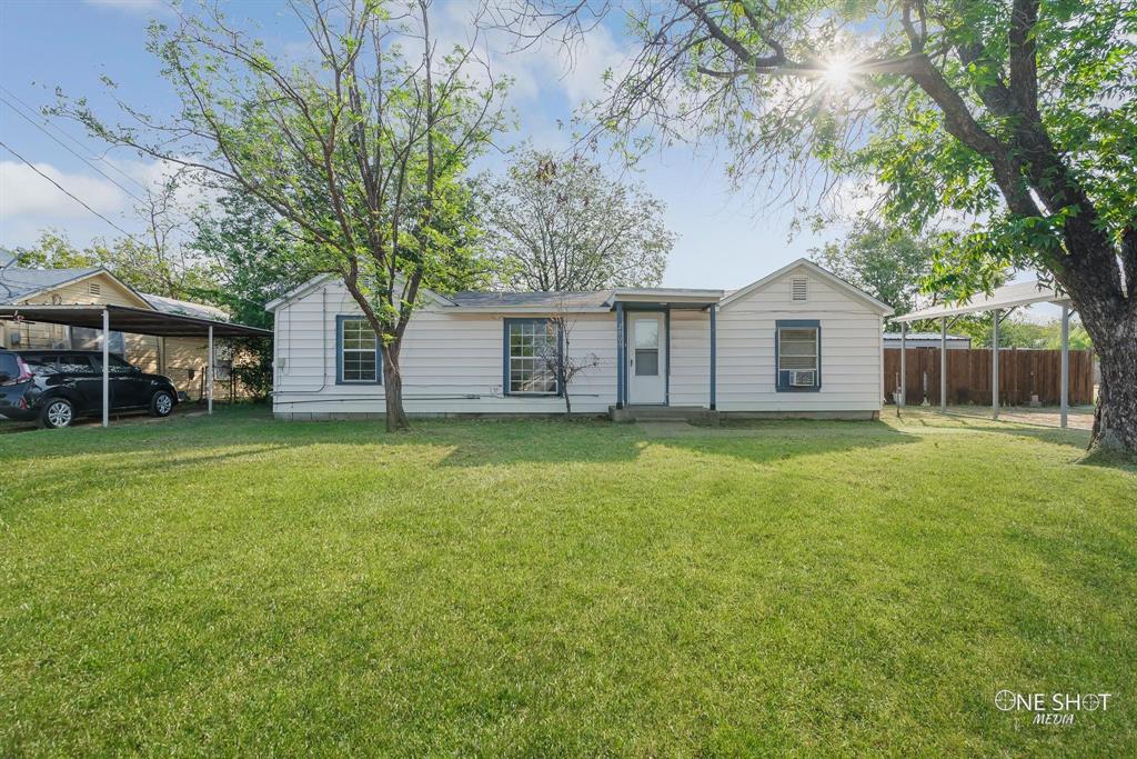 a view of a house with a backyard and a tree