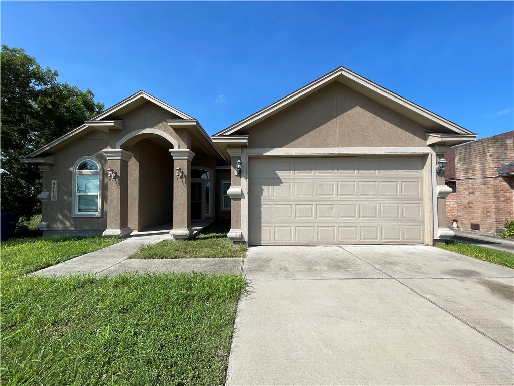 a front view of a house with a yard and garage