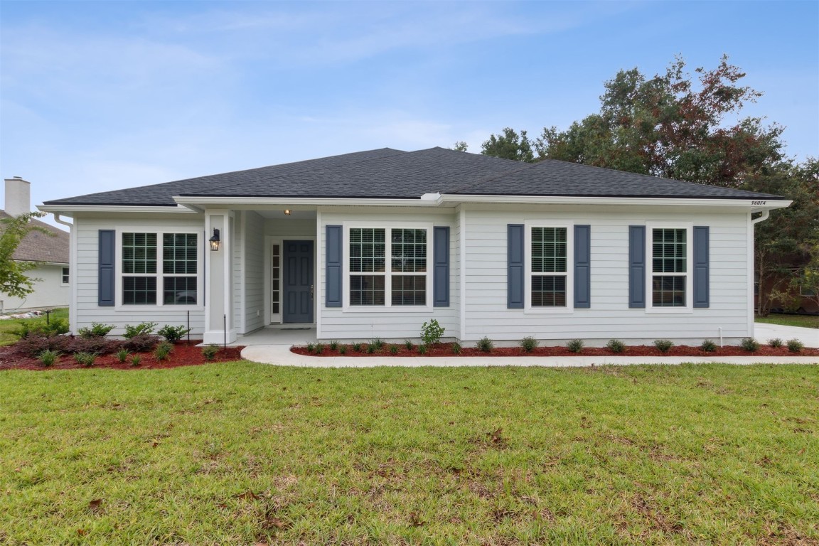 a front view of a house with a garden and yard