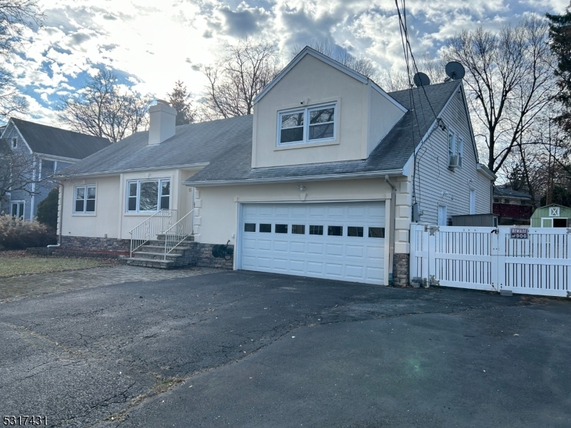 a view of a house with a yard and large tree