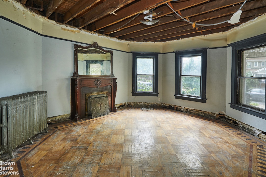 a view of an empty room with a fireplace and a window