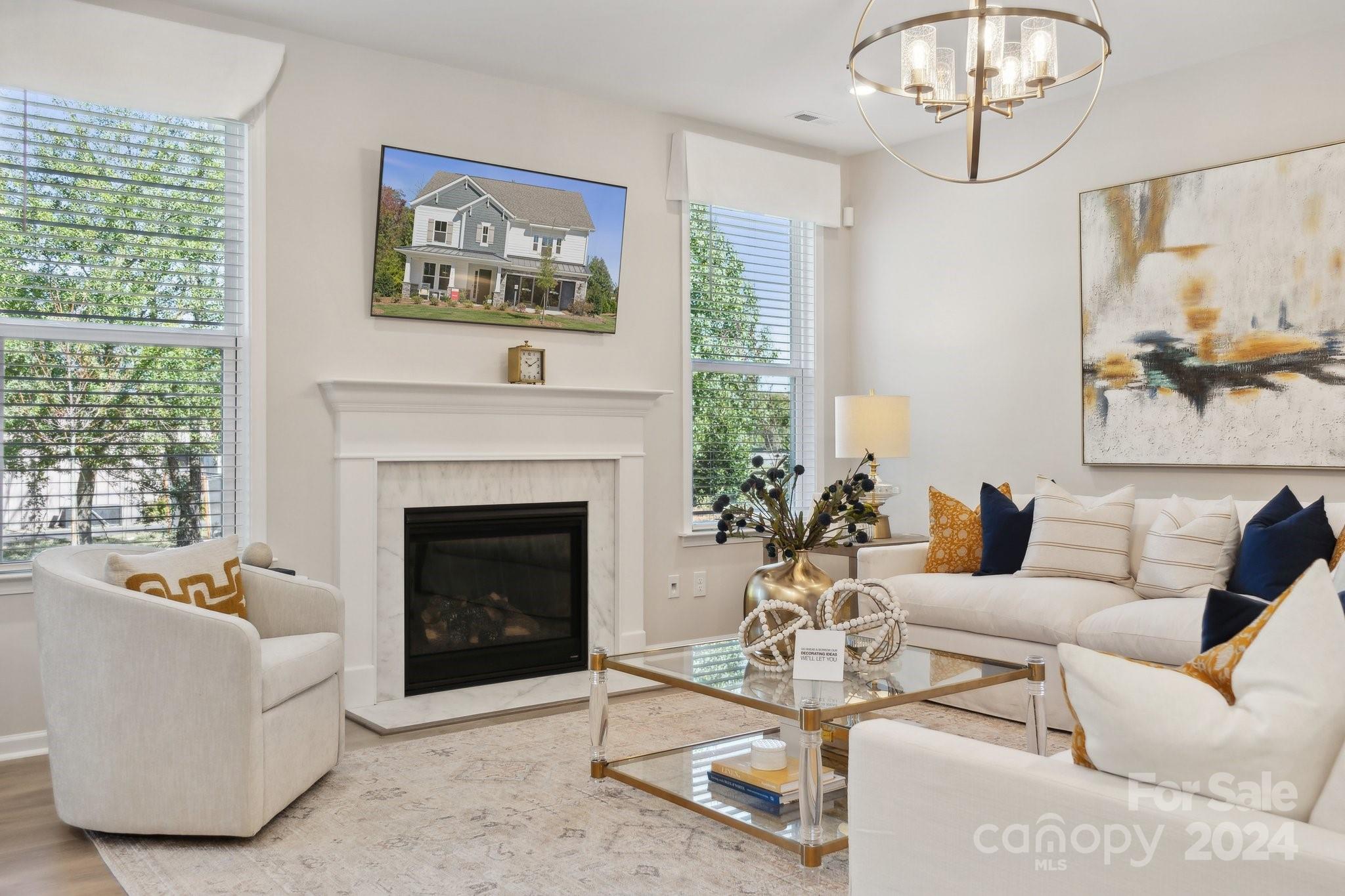 a living room with furniture a chandelier and a fireplace