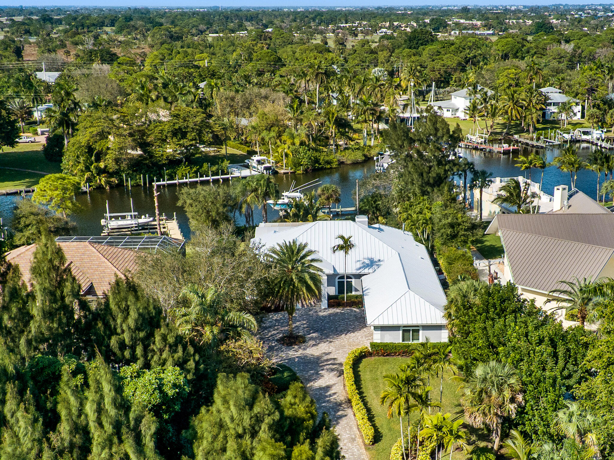 an aerial view of a house with swimming pool and large trees