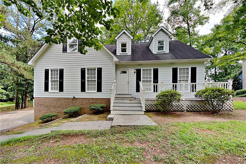 a front view of a house with a yard and potted plants