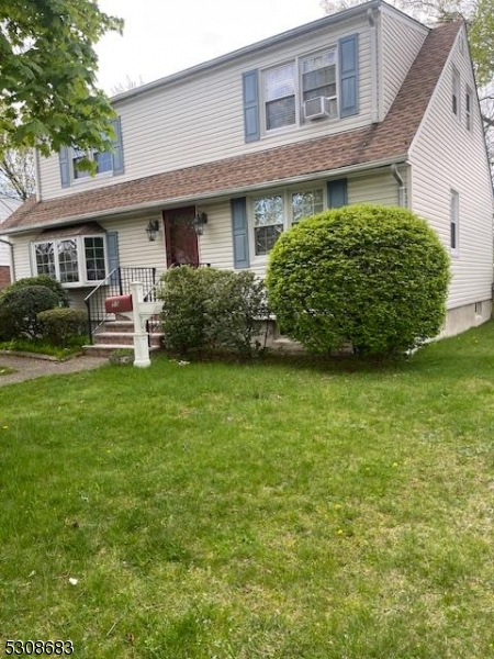 a front view of a house with a garden and yard